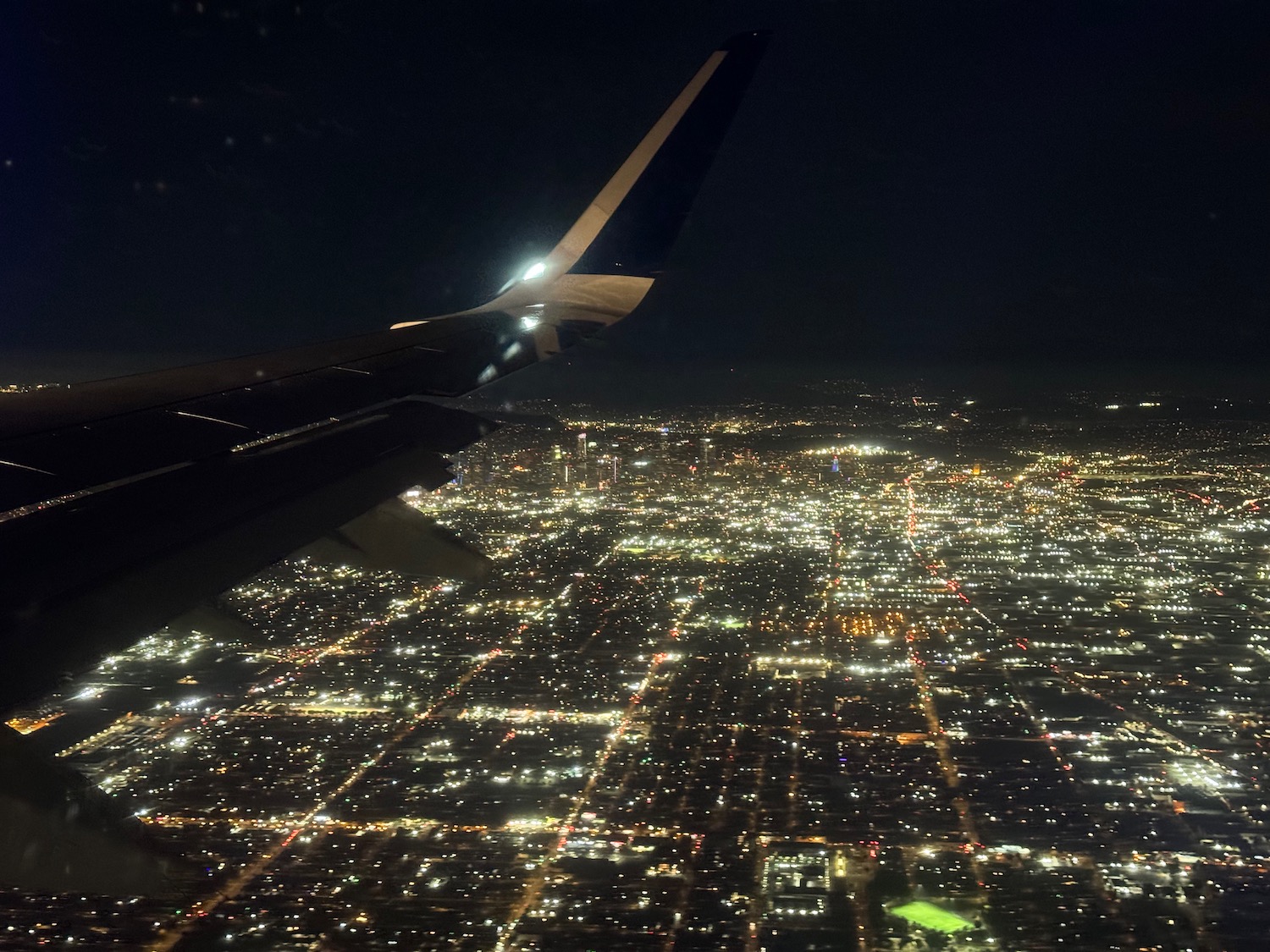 an airplane wing and city lights at night