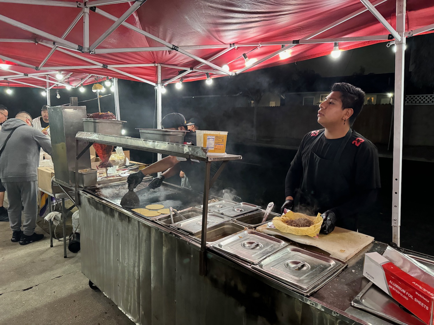 a man cooking food at a food stand