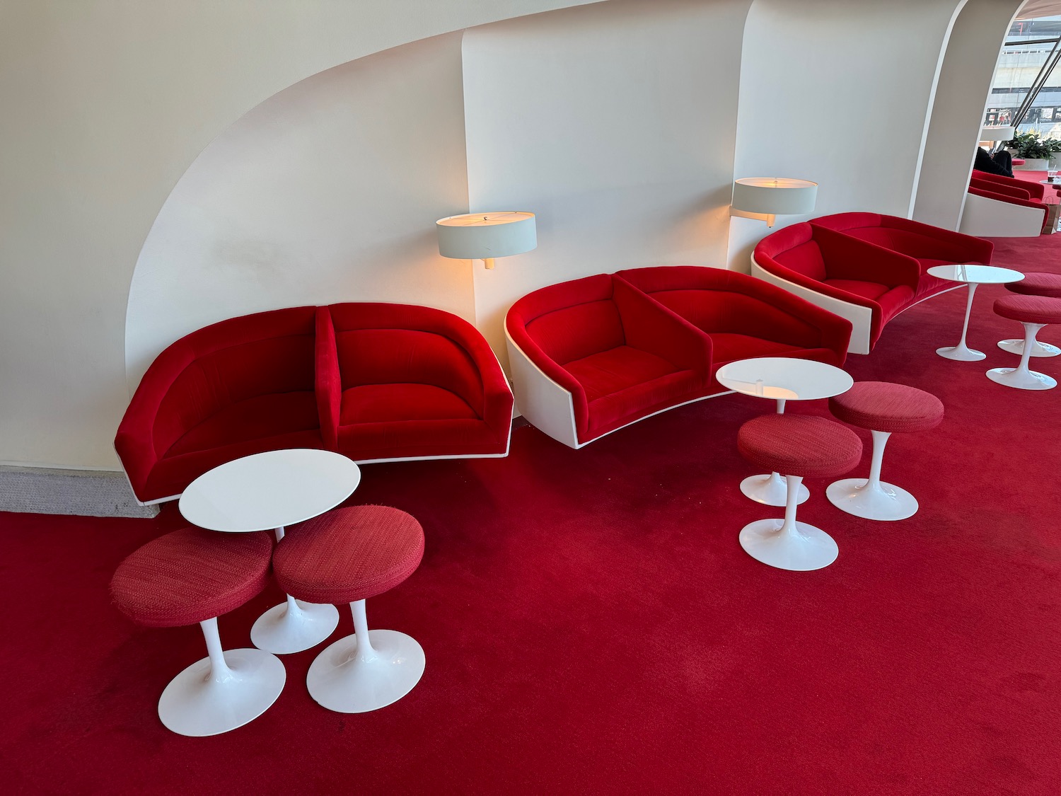 a group of red couches and tables in a room