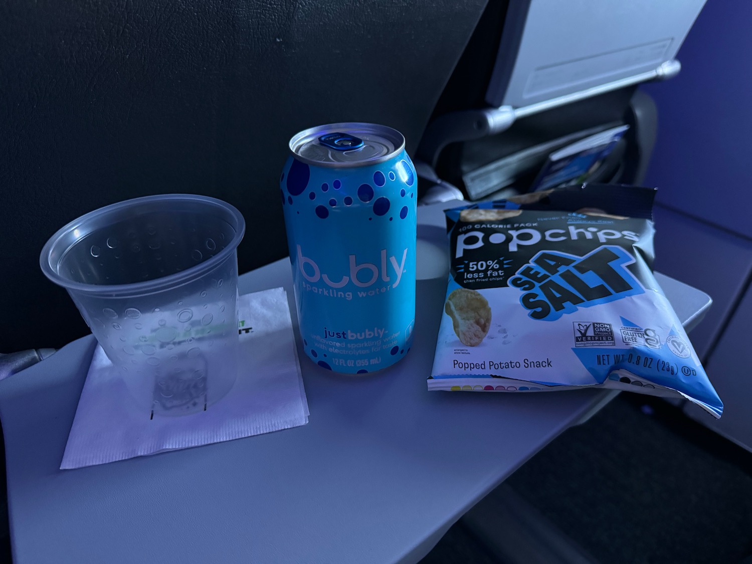 a can of soda and a plastic cup on a table