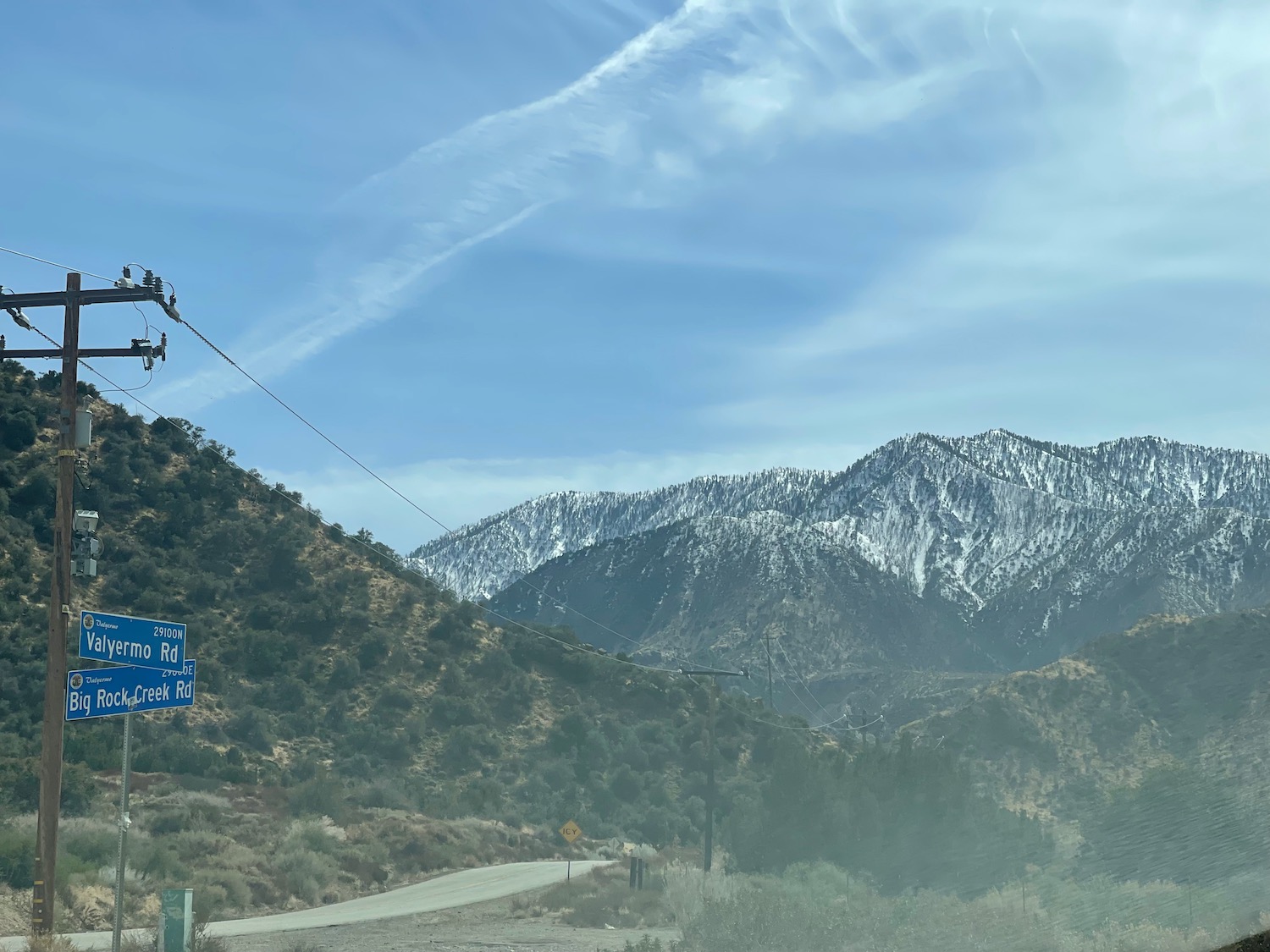 a person on a power line above a road with mountains in the background