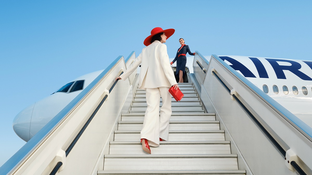 a woman in a white suit walking up stairs