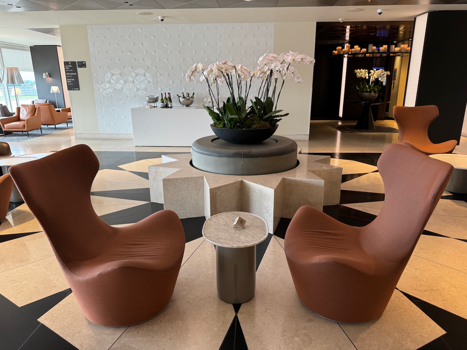 chairs in a lobby with a plant in the center