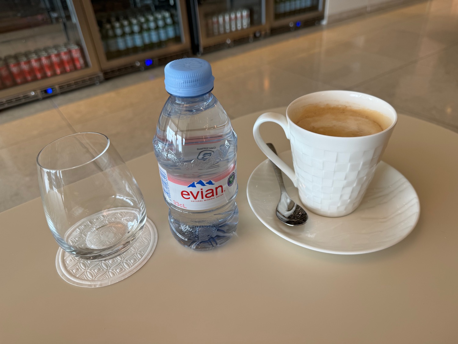 a cup of coffee and a bottle of water on a table