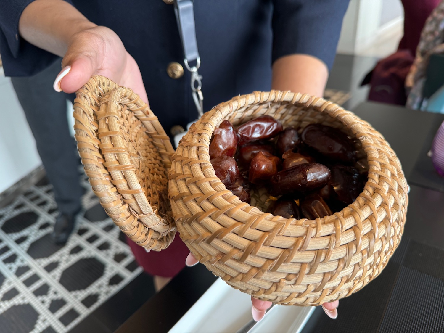 a hand holding a basket of dates