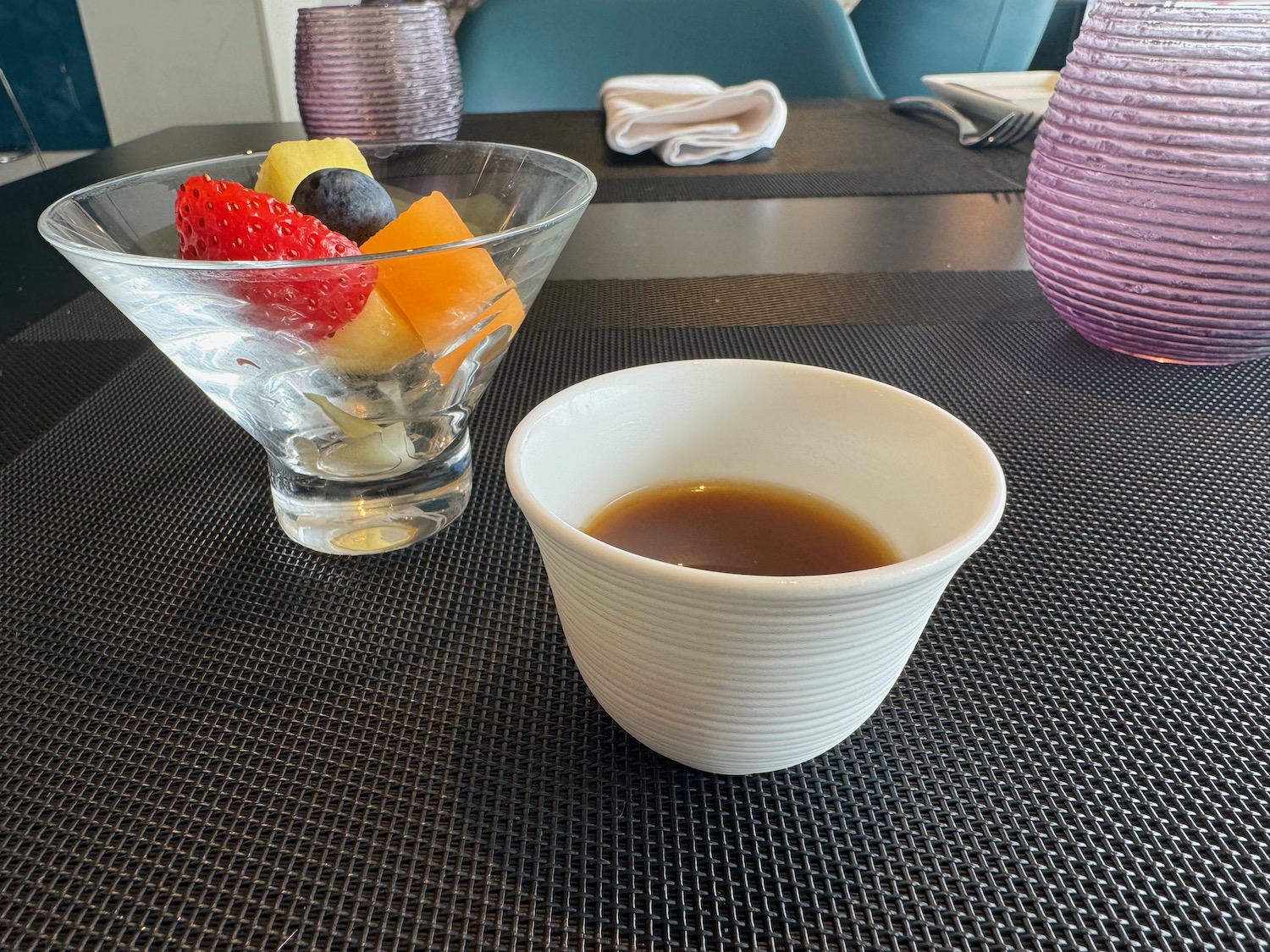 a bowl of fruit and a bowl of liquid on a table