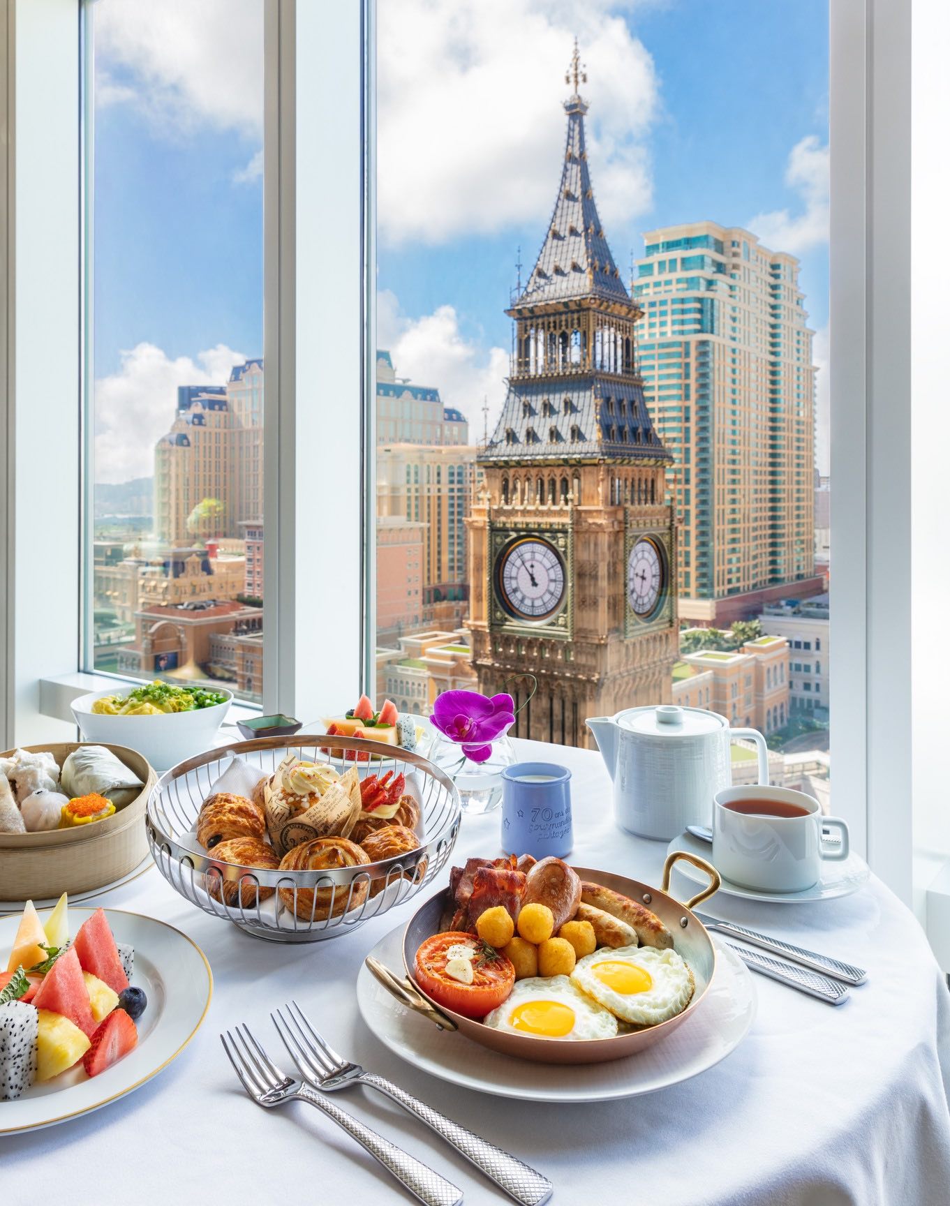 a table with food on it and a large clock tower in the background