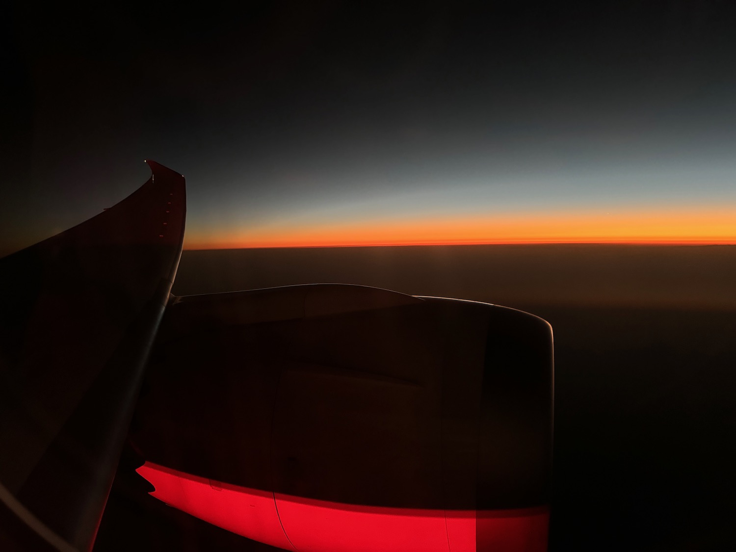 an airplane wing with a sunset in the background