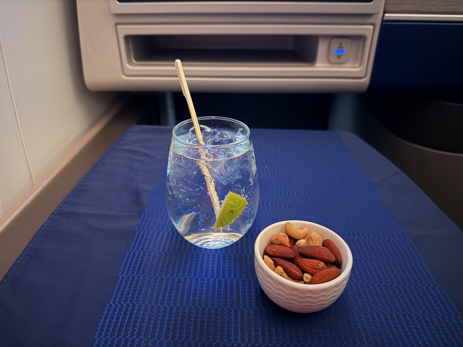 a glass of water and a bowl of nuts