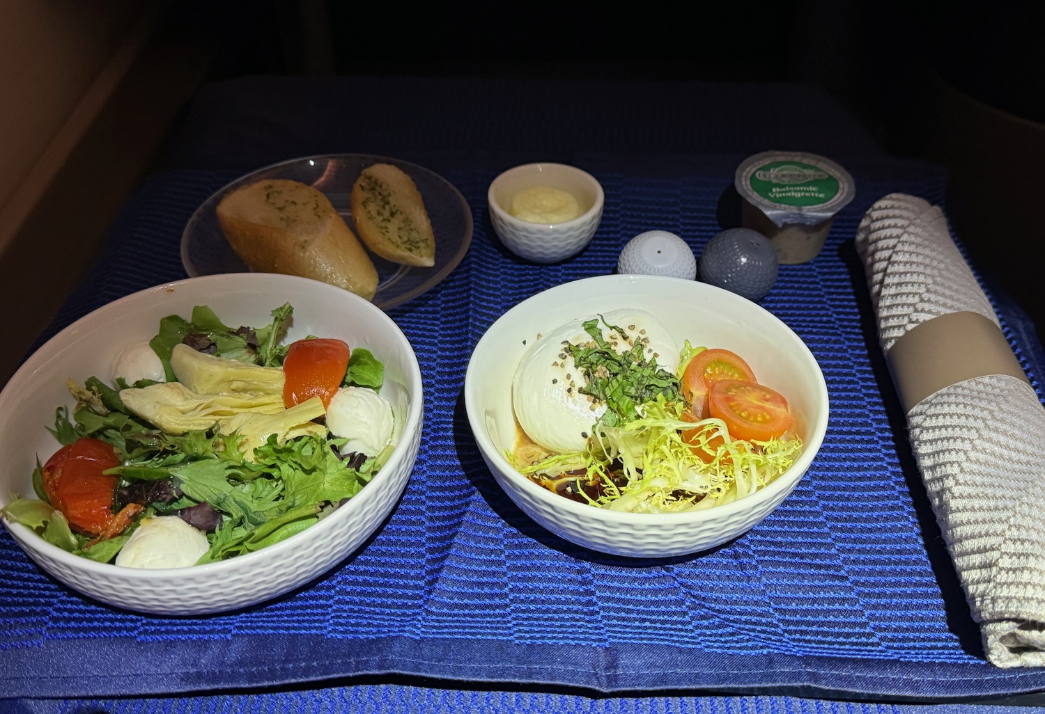 a bowl of salad and bread on a table