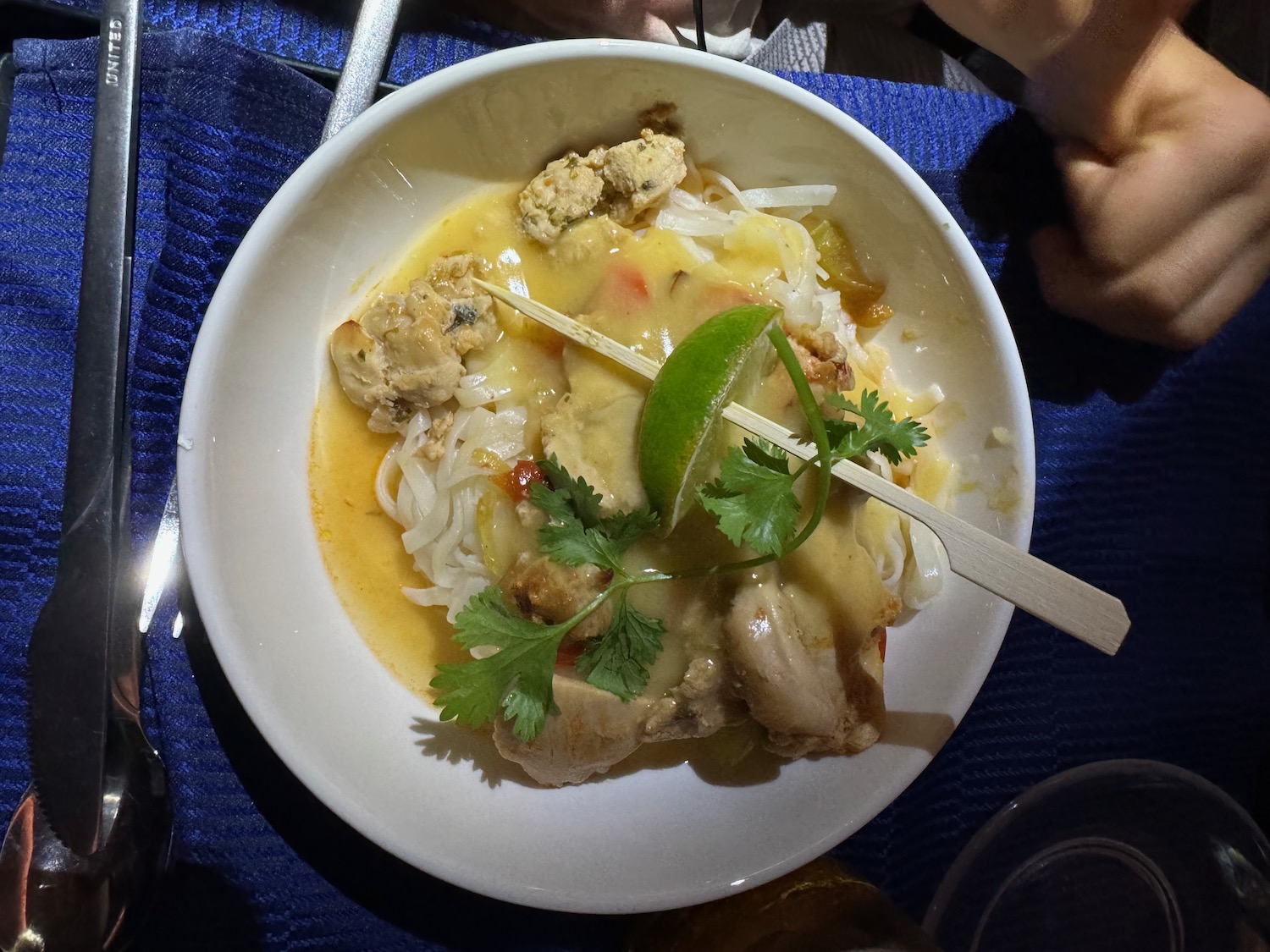 a bowl of soup with chopsticks and a fork