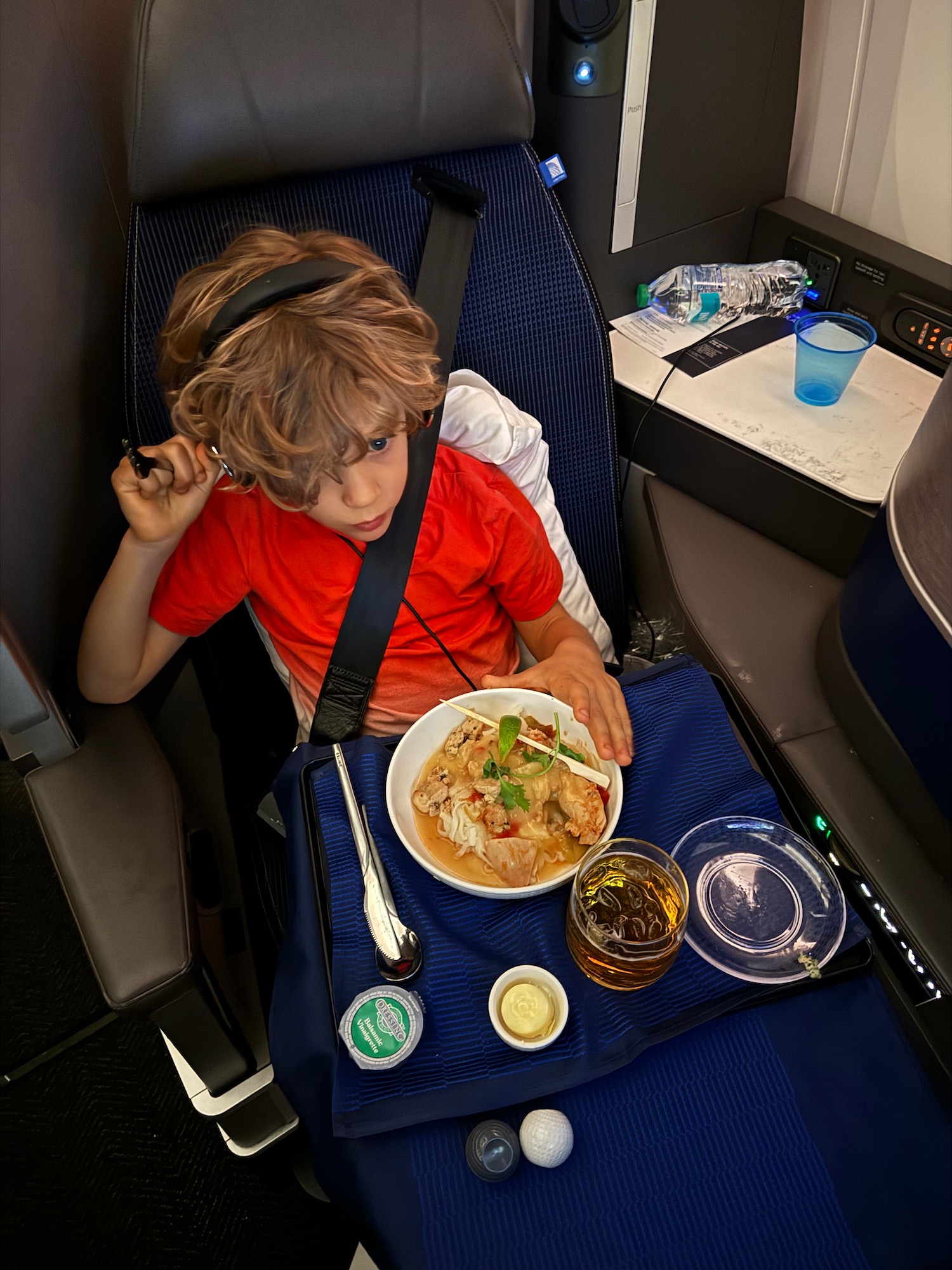 a boy sitting in a chair eating food