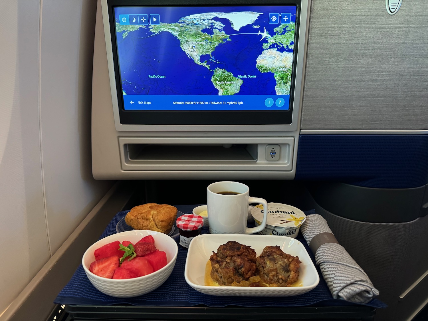 a tray of food and a cup of coffee on a tray in an airplane