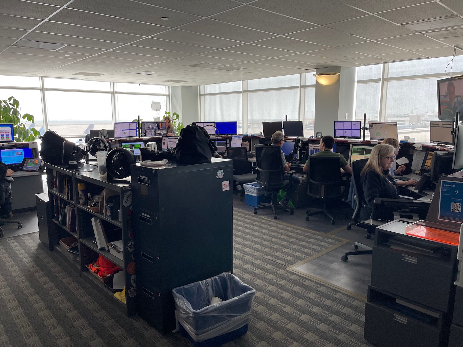 a group of people sitting at desks in an office