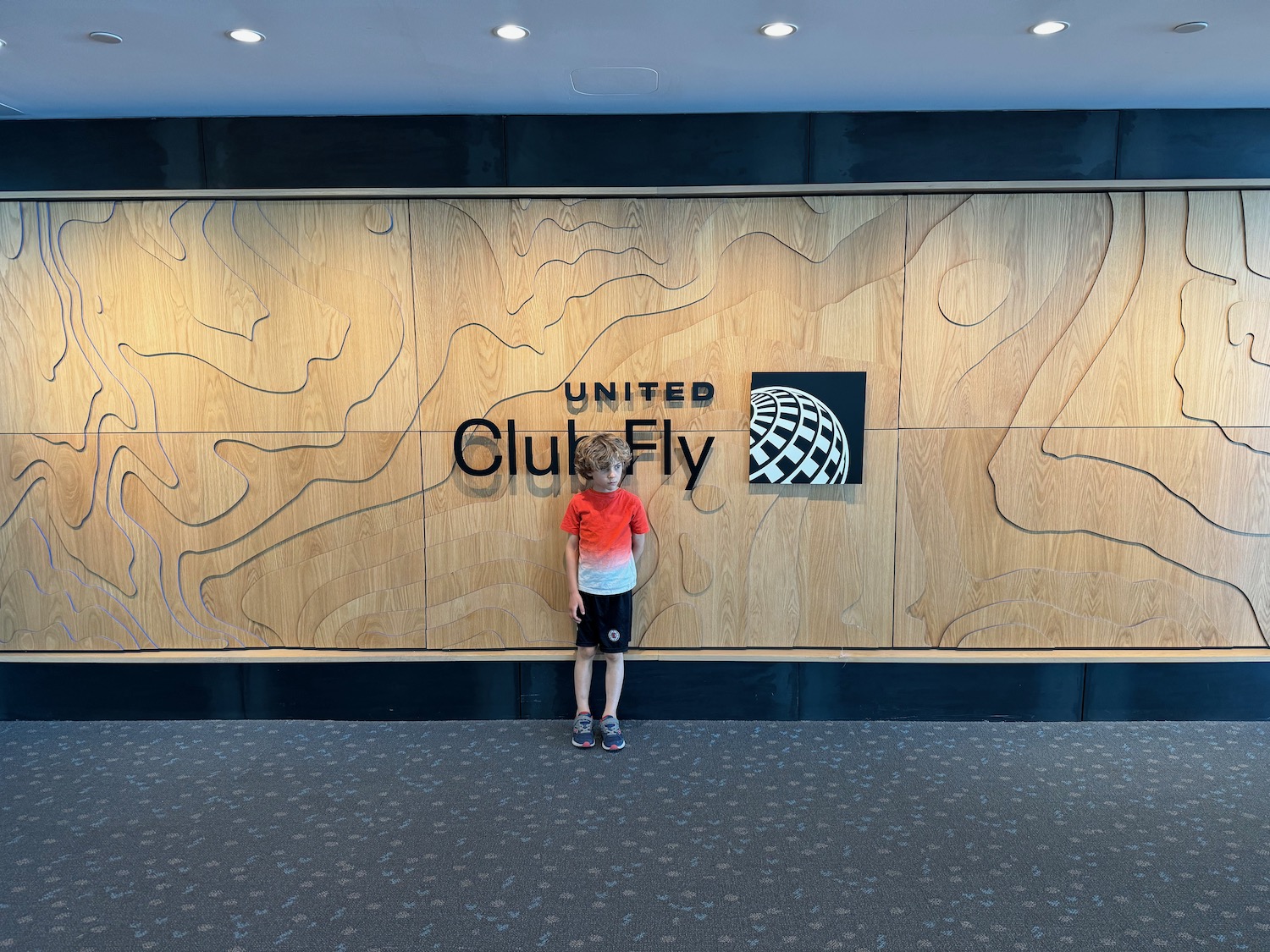 a boy standing in front of a large sign