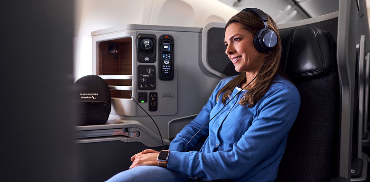 a woman wearing headphones and sitting in an airplane