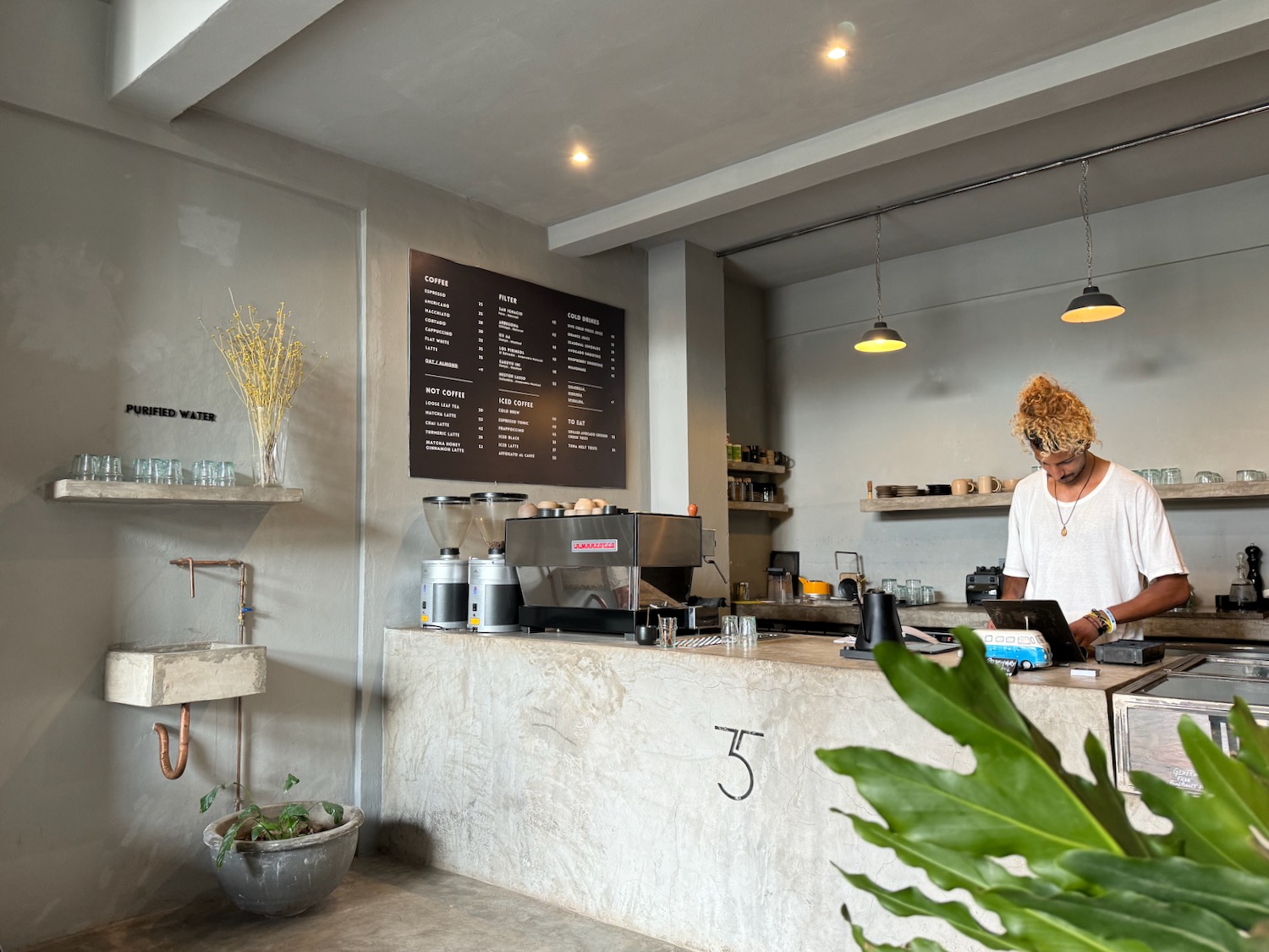 a man working at a counter in a coffee shop