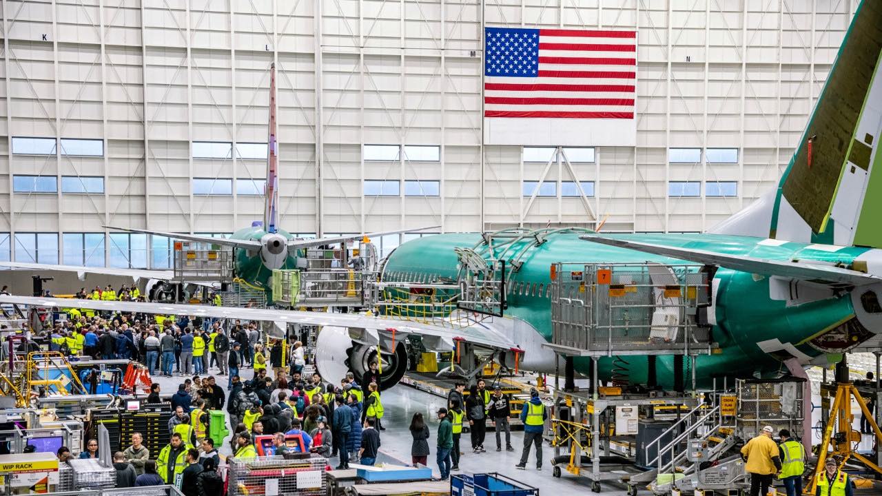 a group of people in a hangar with an airplane