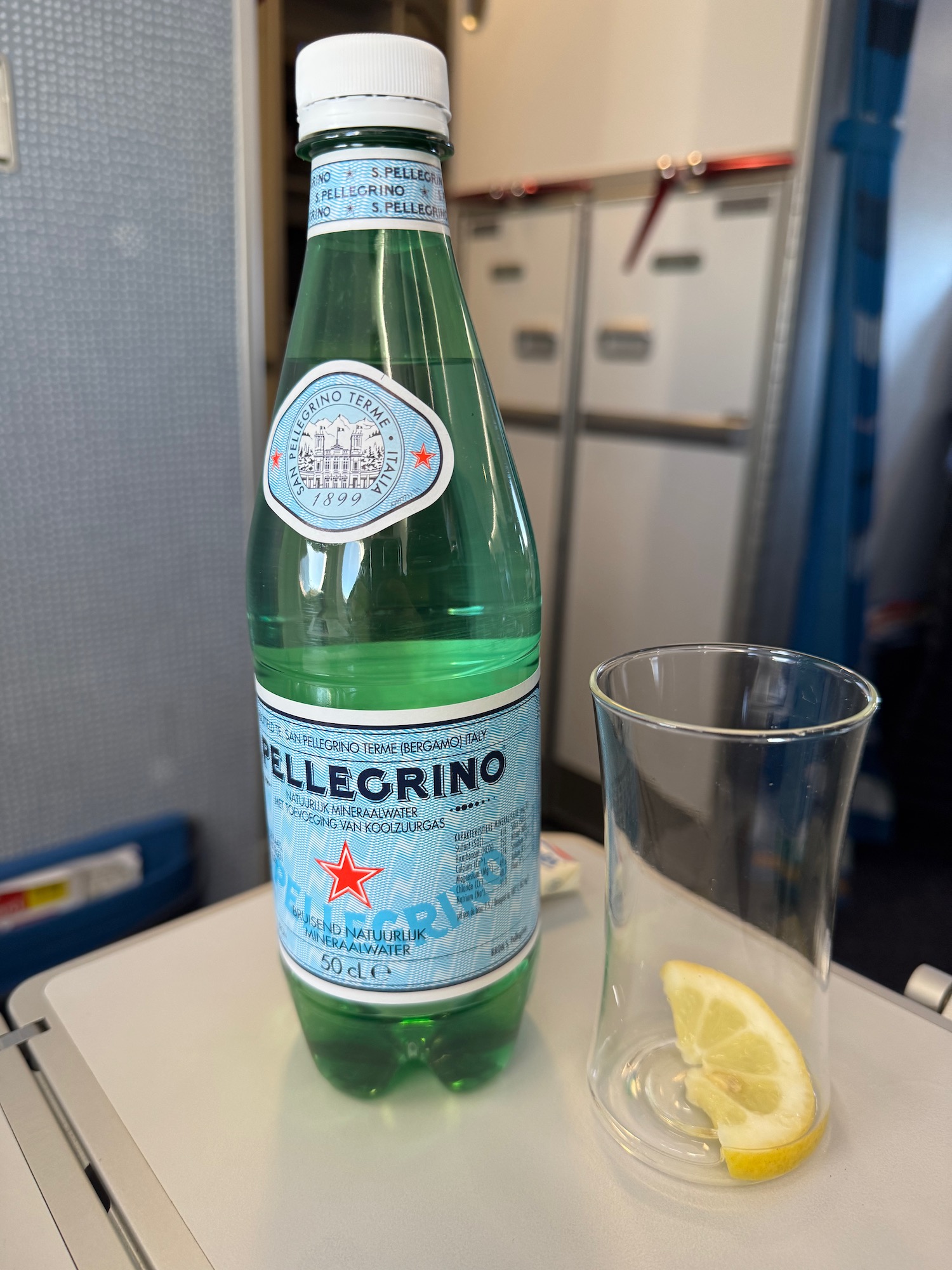 a bottle of green liquid and a glass with a lemon on a table