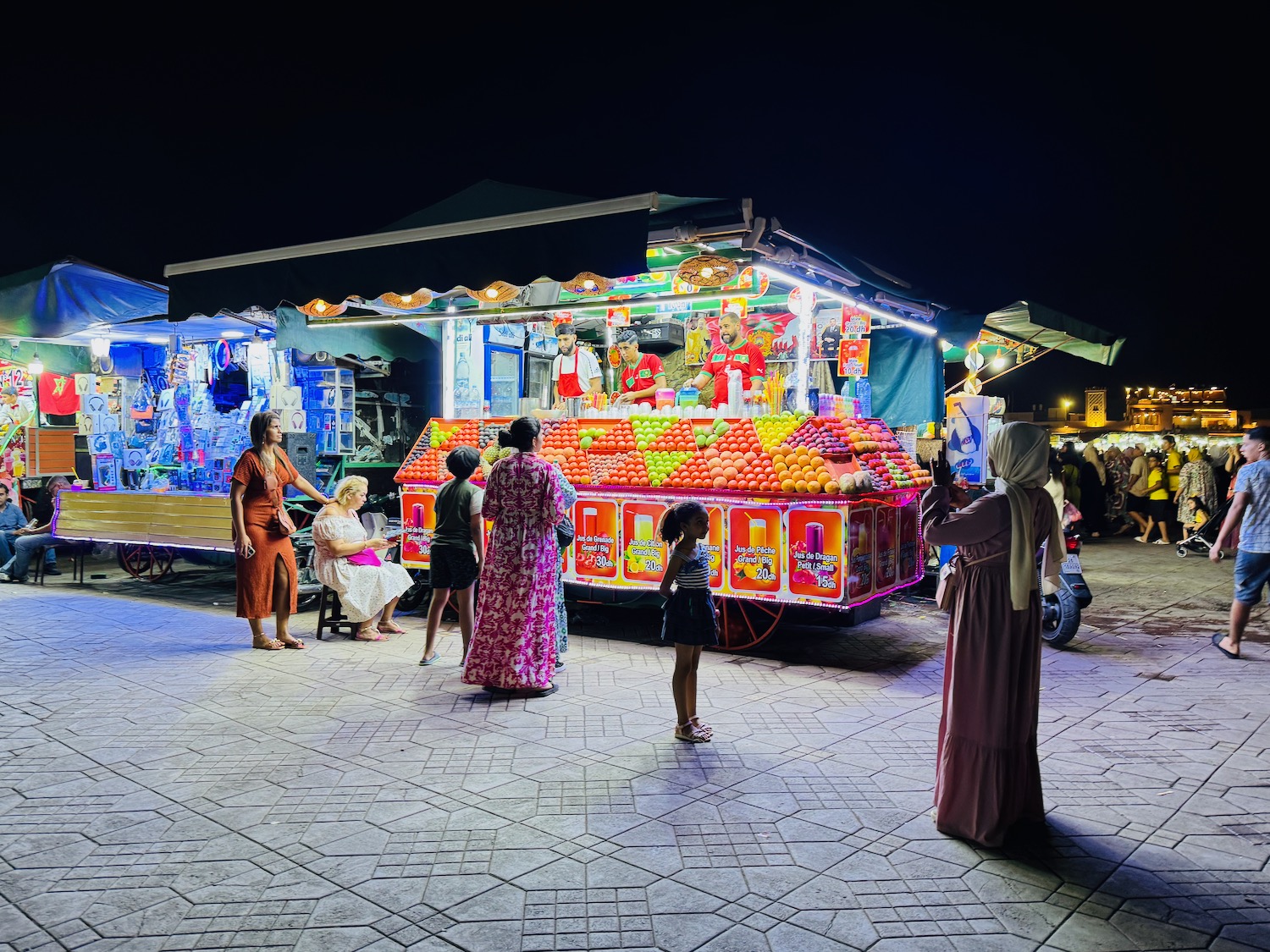 a group of people standing in front of a fruit stand