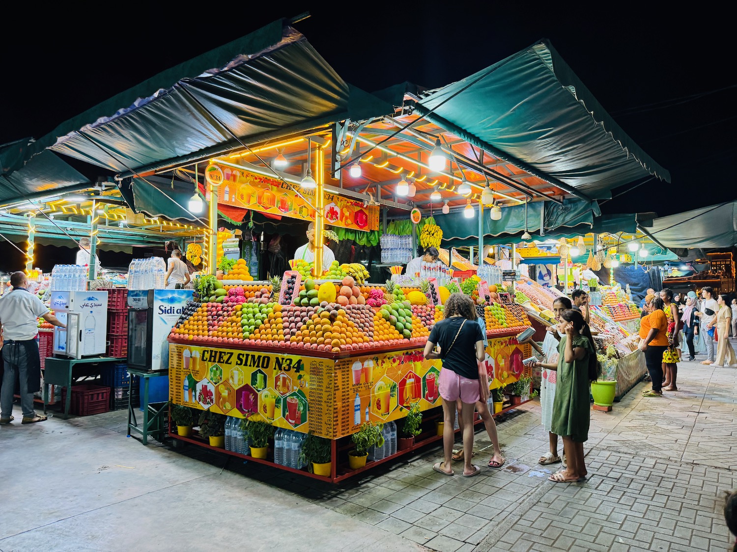 a group of people standing in front of a fruit stand