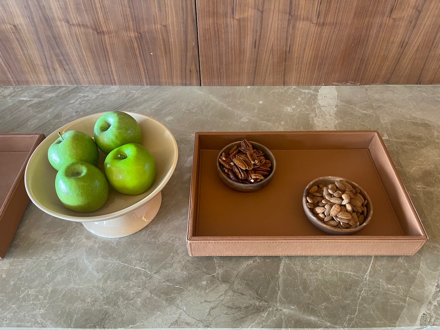 a bowl of apples and nuts on a tray