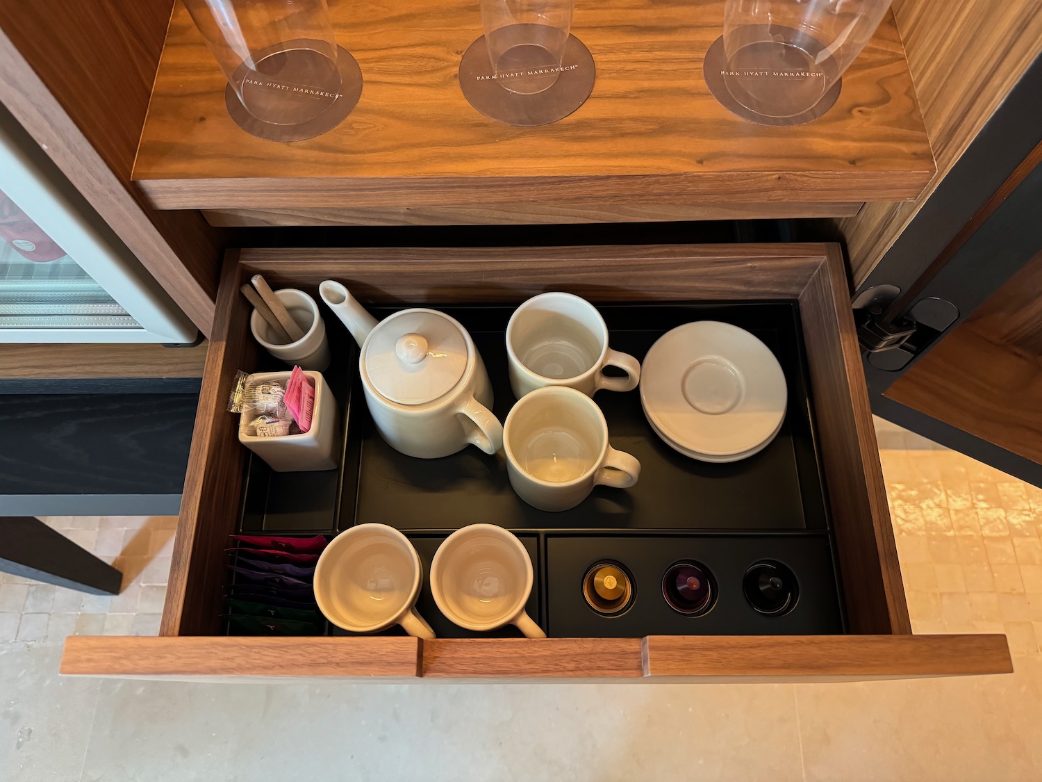 a drawer with teapots and cups