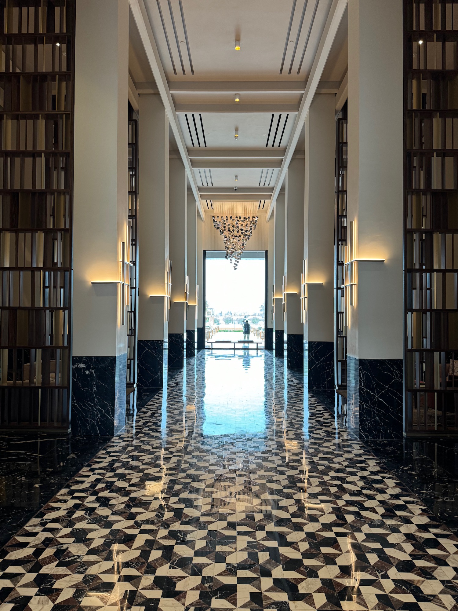 a hallway with bookshelves and chandelier