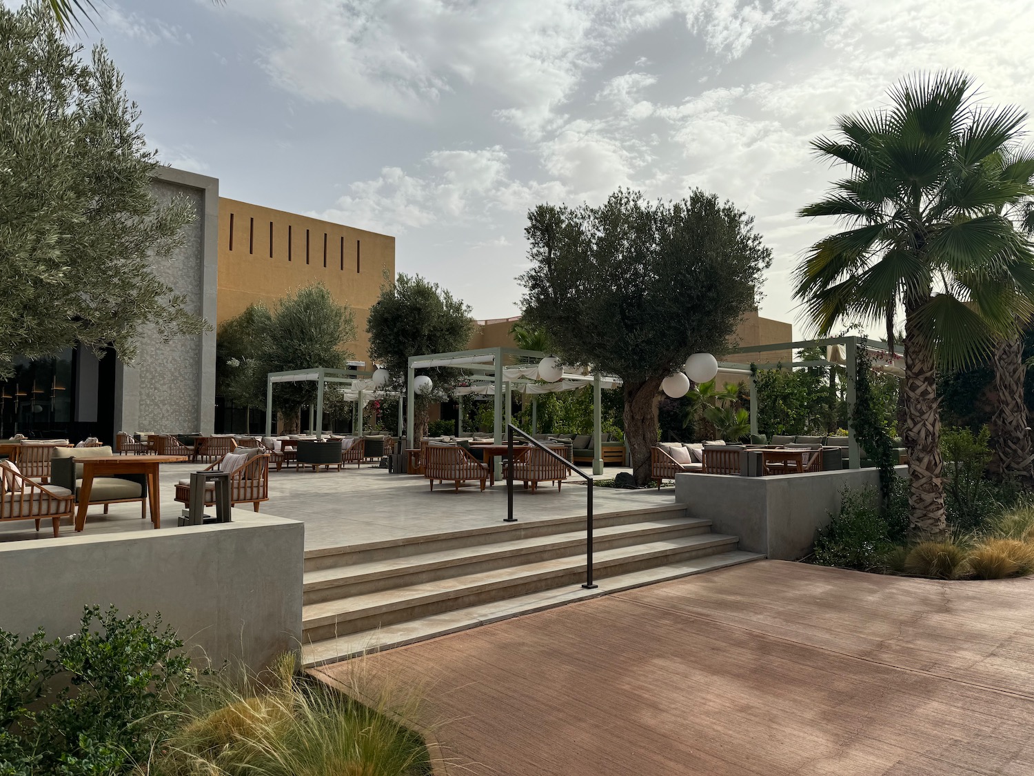 a patio with tables and chairs and trees