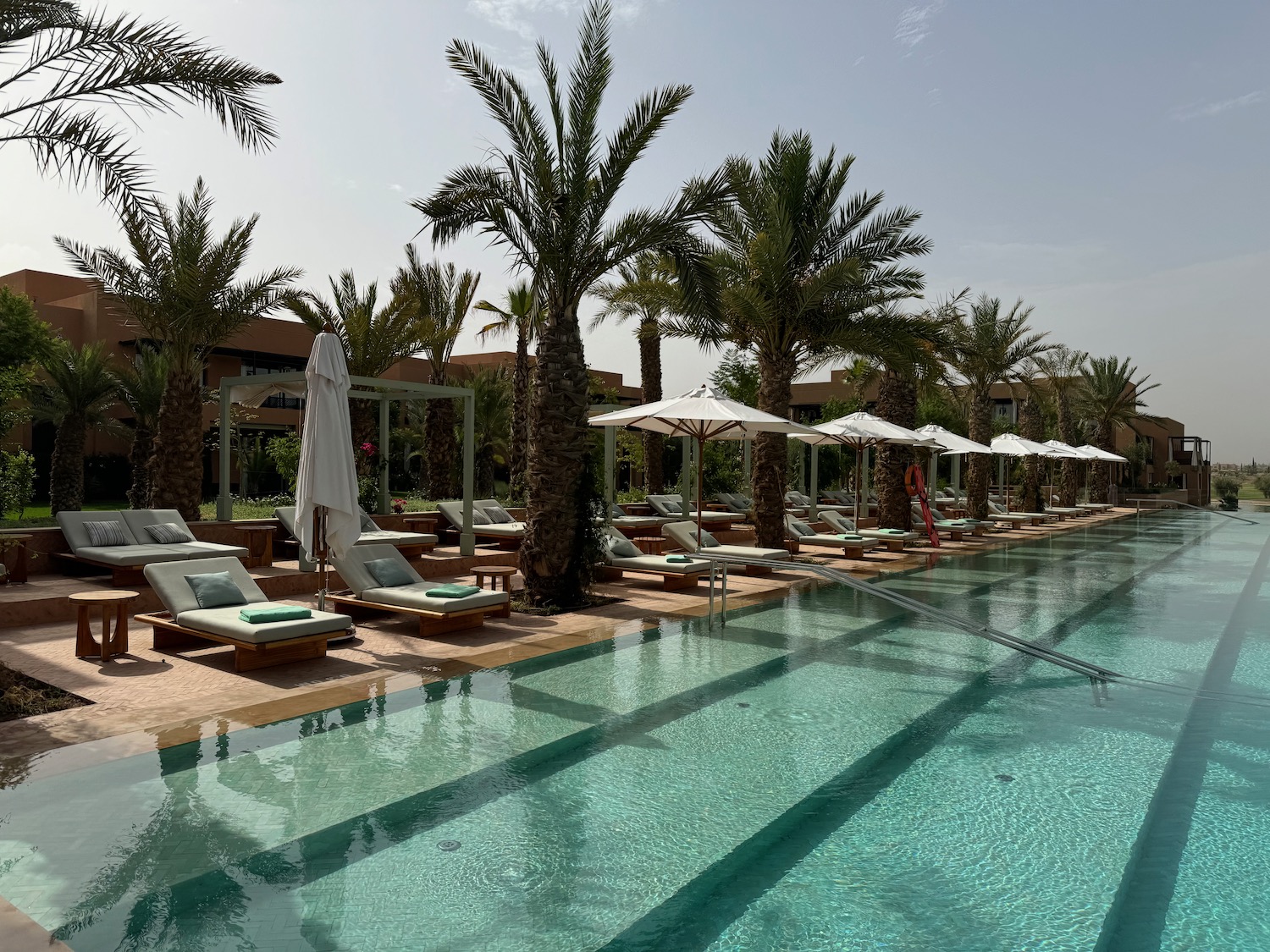 a pool with lounge chairs and umbrellas