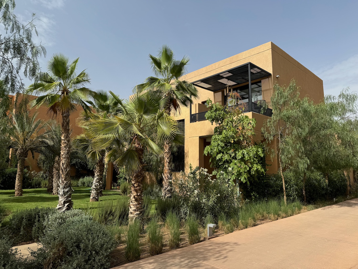 a building with palm trees and a walkway