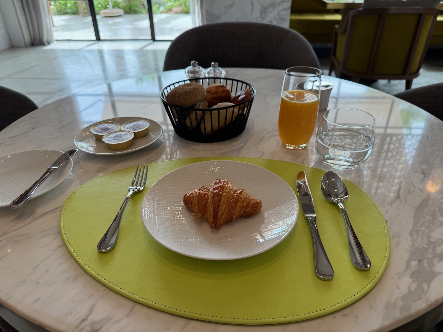 a plate of croissant and a basket of food on a table