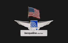 a silver wings with a flag and a name tag