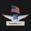 a silver wings with a flag and a name tag