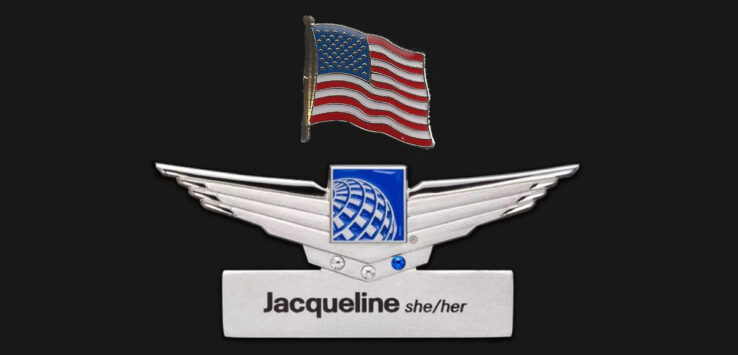 a silver wings with a flag and a name tag