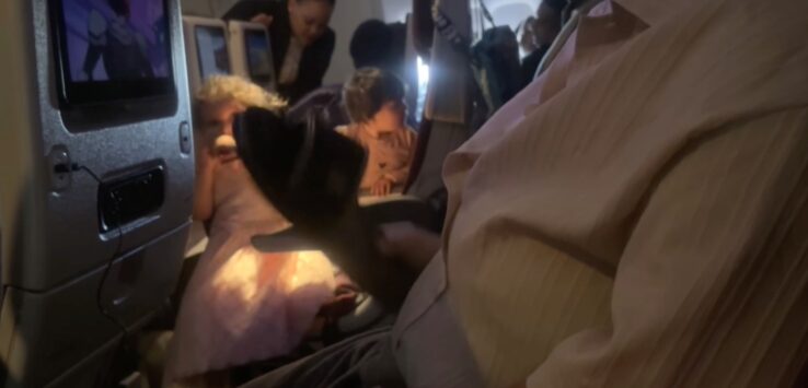 A passenger cabin on a Qatar Airways aircraft, referencing an incident in which a child stabbed another passenger with a metal fork during the flight.