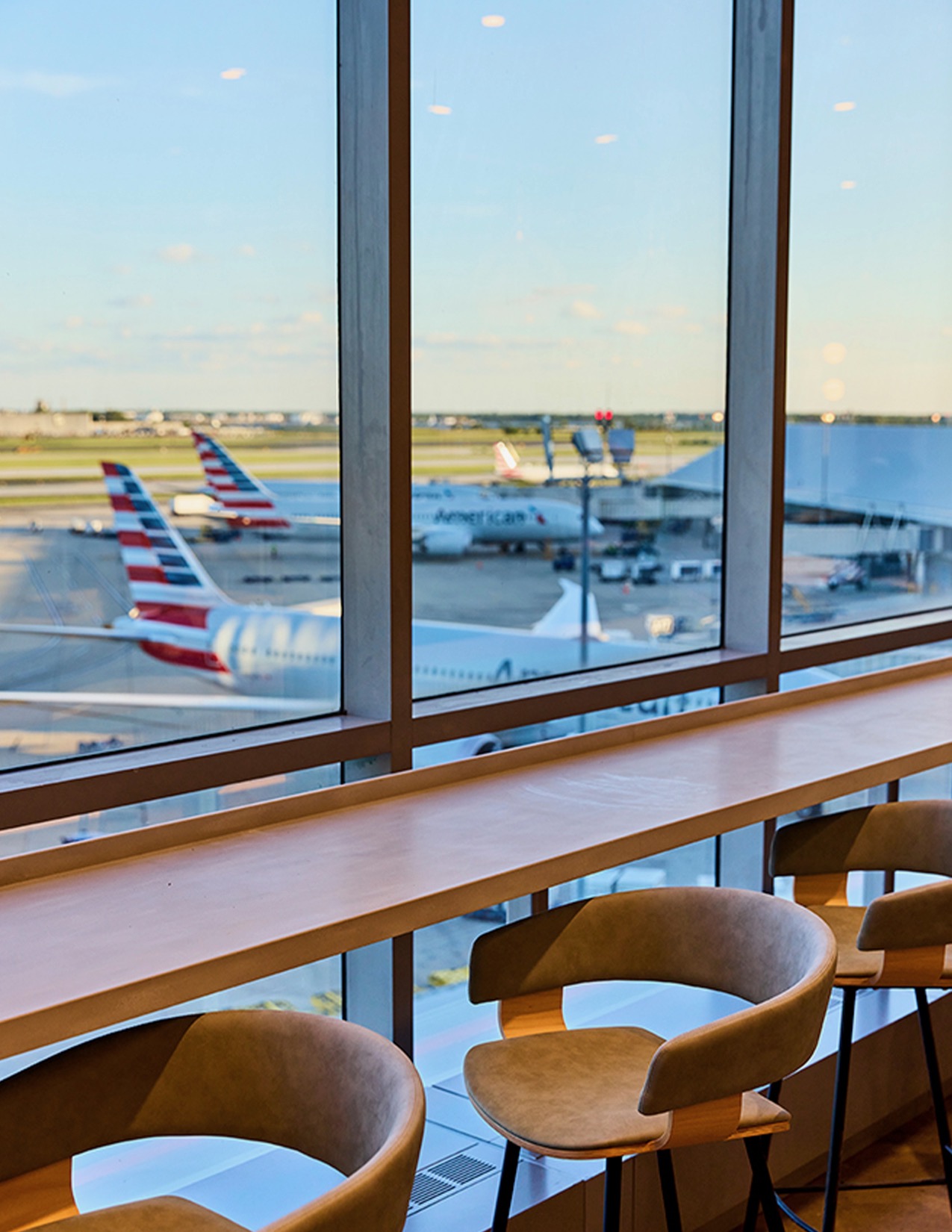 a table with chairs and a table with chairs in front of a window with airplanes in the background