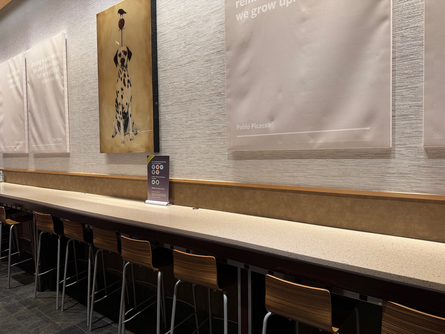 a bar with chairs and a painting on the wall