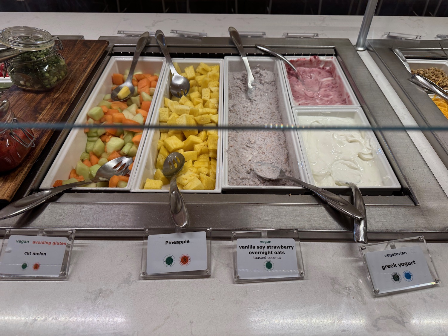 a tray of fruit and yogurt in a buffet