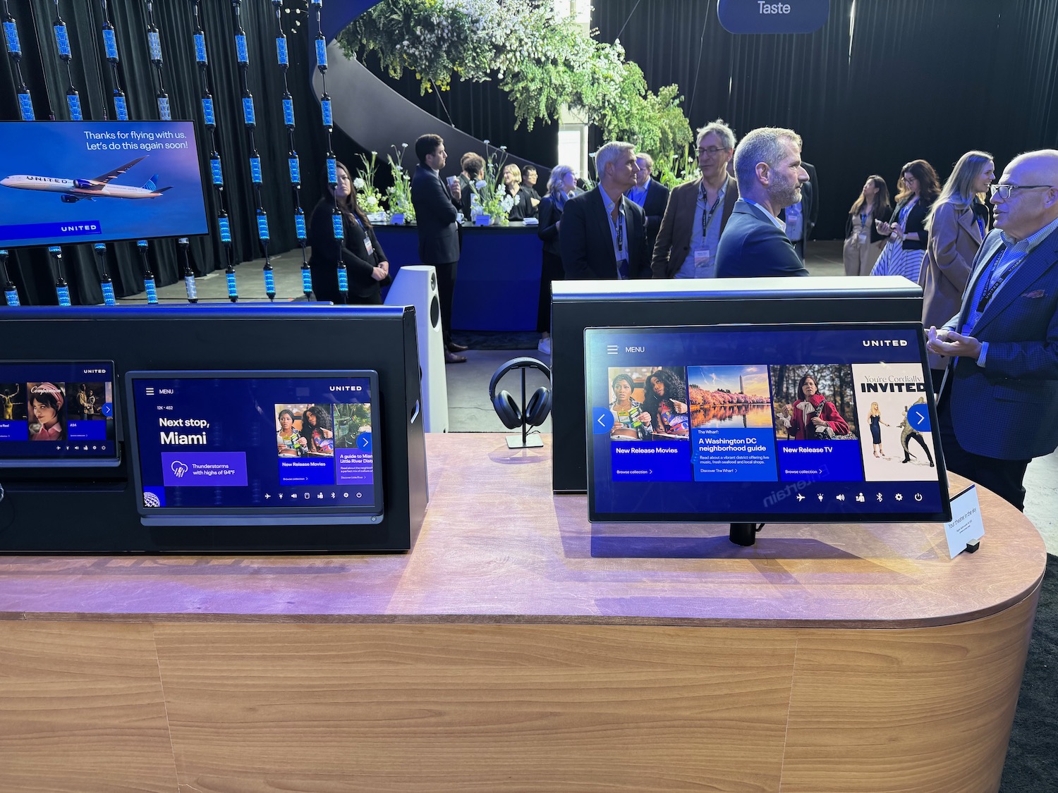 a group of people standing around a table with monitors