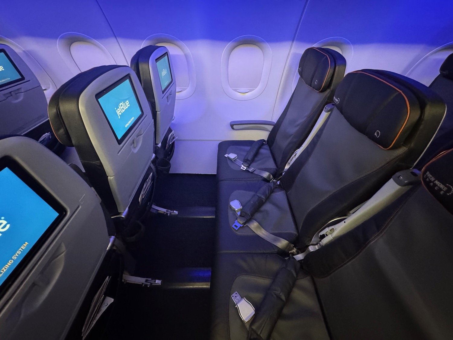 seats in an airplane with seats and monitors