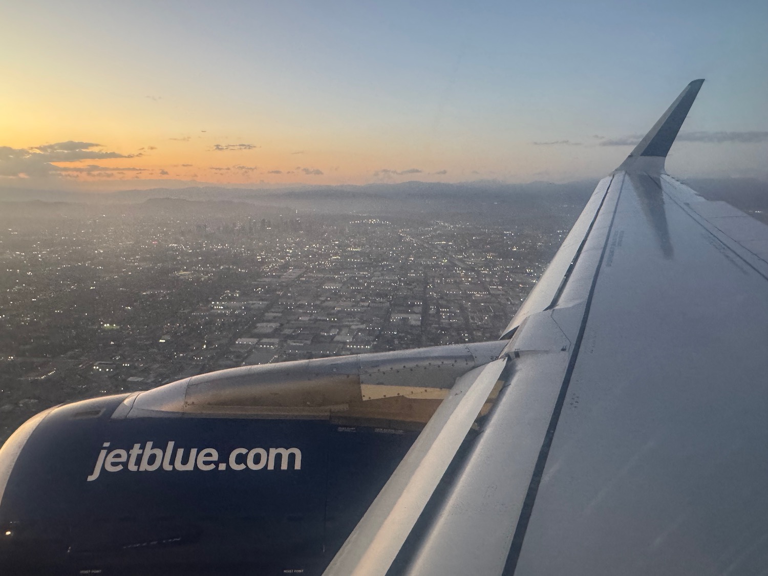 an airplane wing and city in the distance