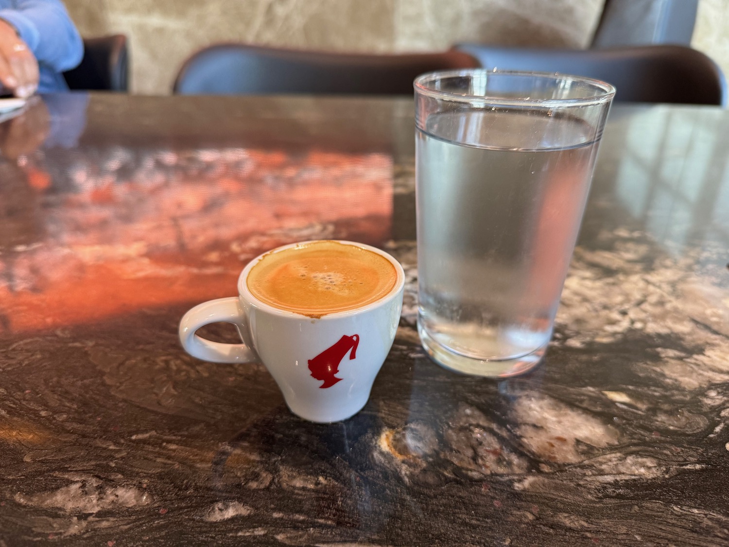 a cup of coffee and a glass of water on a table