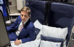 a man in a suit sitting on a bed