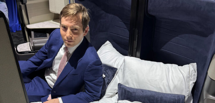 a man in a suit sitting on a bed