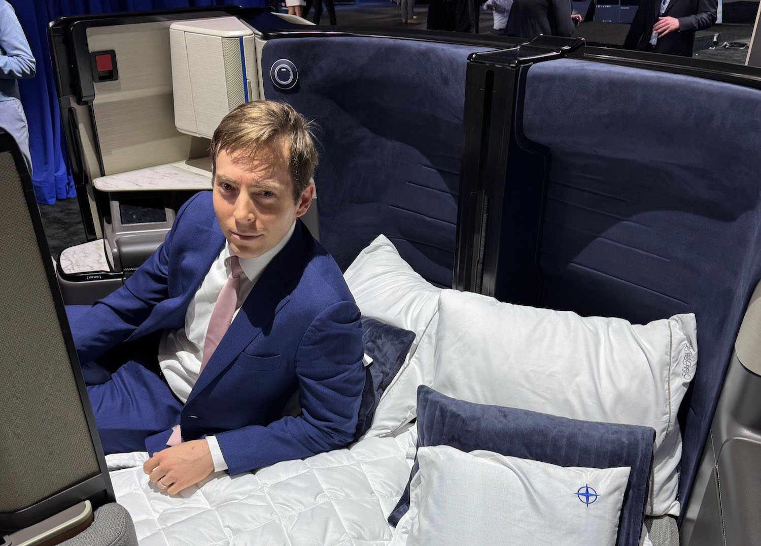 a man in a suit sitting on a bed