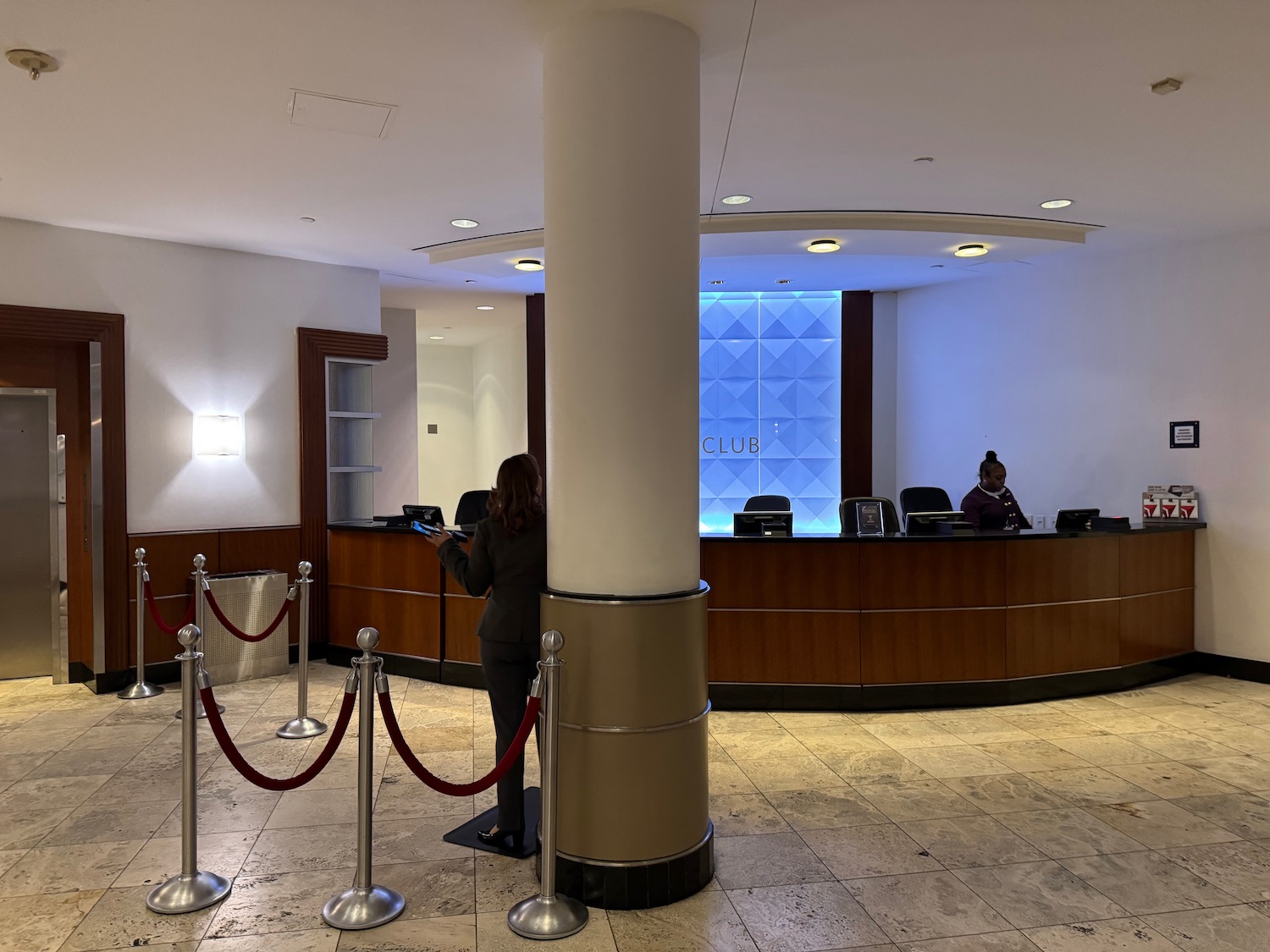 a reception area with a couple people standing behind a column