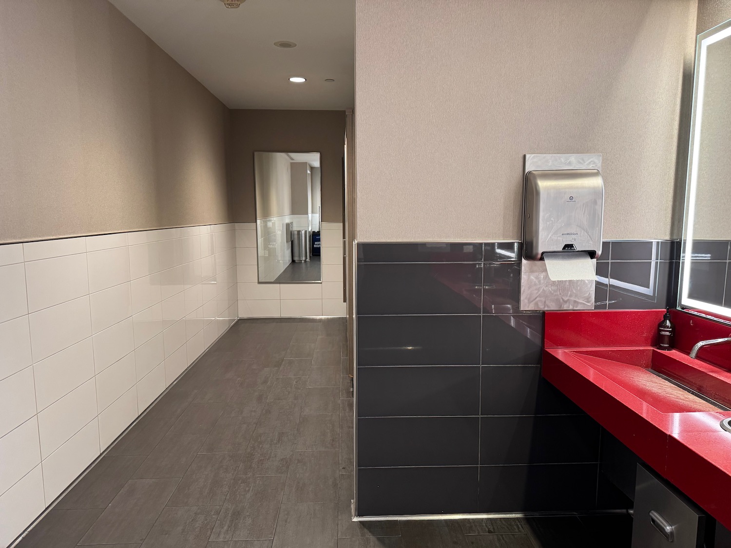 a bathroom with a red sink and a mirror