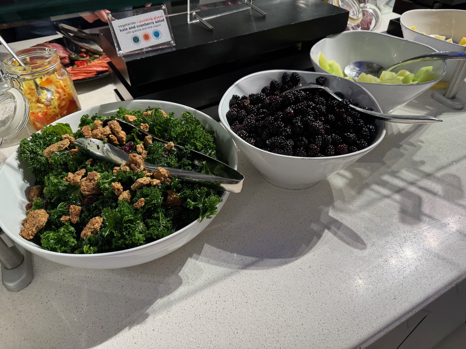 a bowl of salad with fruit and spoons