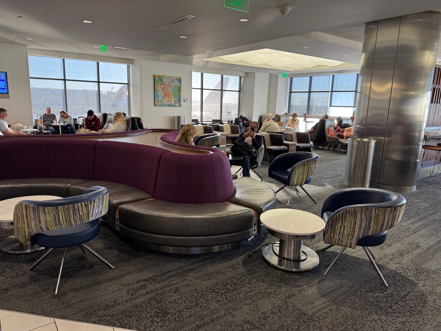 a group of people sitting in a room with tables and chairs